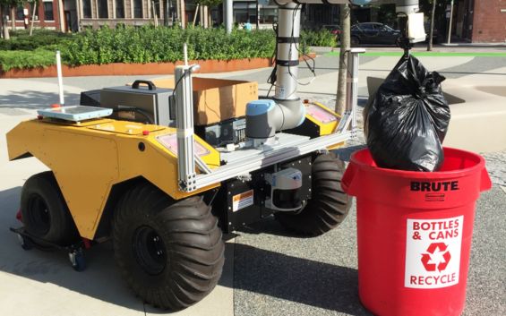 Robot mobile autonome Husky ramassant des sacs poubelles